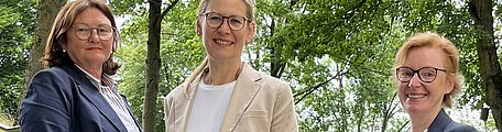  Drei Frauen aus der GeBO-Akademie stehen im Park.